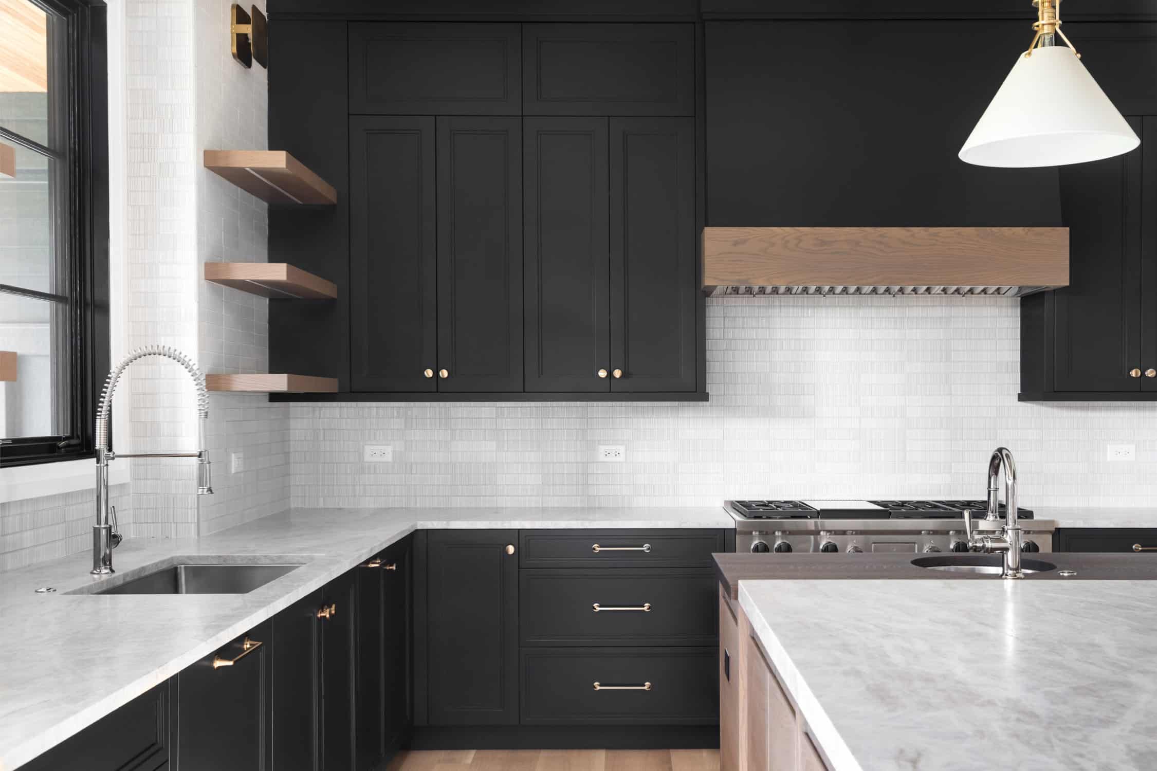 A black kitchen with stainless steel appliances, preventing paint wear on cabinets