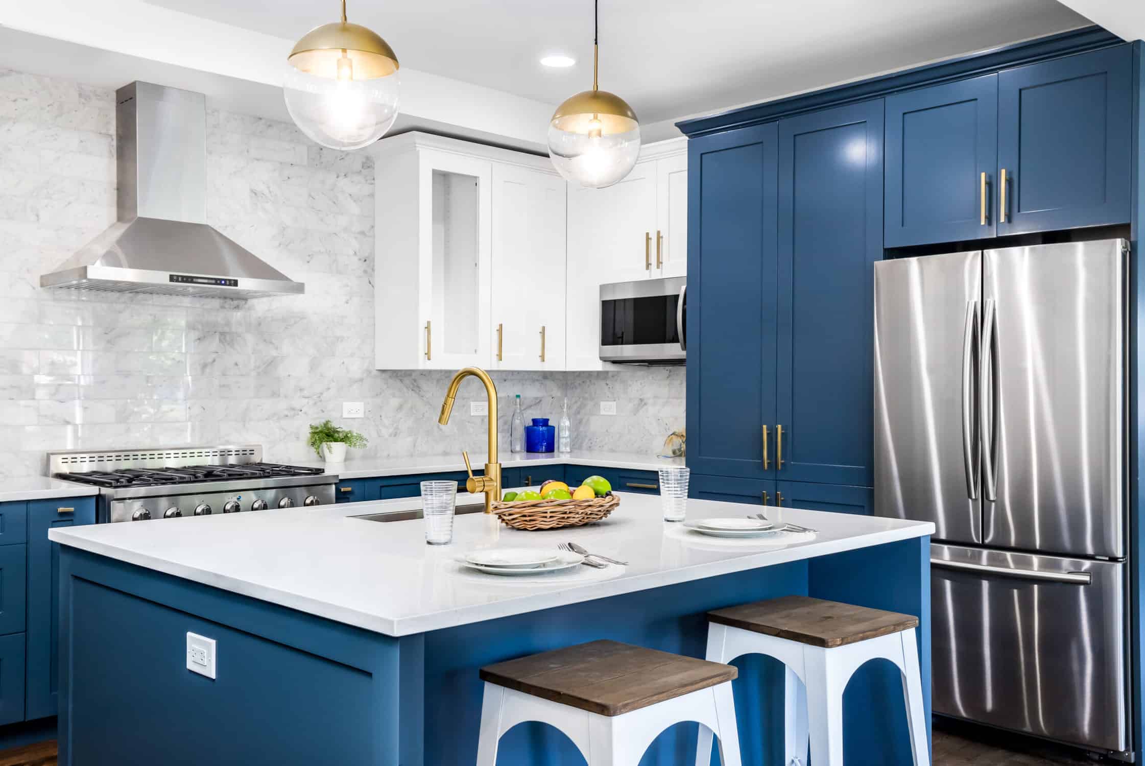 A blue kitchen with stainless steel appliances, preventing paint wear on cabinets