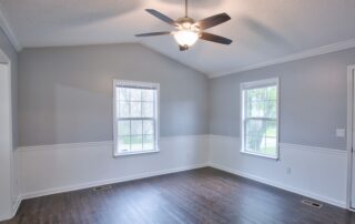 Gray living room interior with vaulted ceilings and chair rail, preparing walls for painting in cooler temperatures